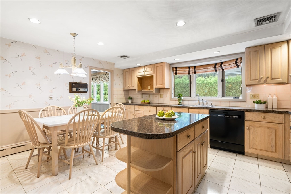 50 Tomahawk Road Arlington, MA 02474 - Photo 15 of 41 a very nice looking kitchen with granite countertop a stove a sink a dining table and chairs