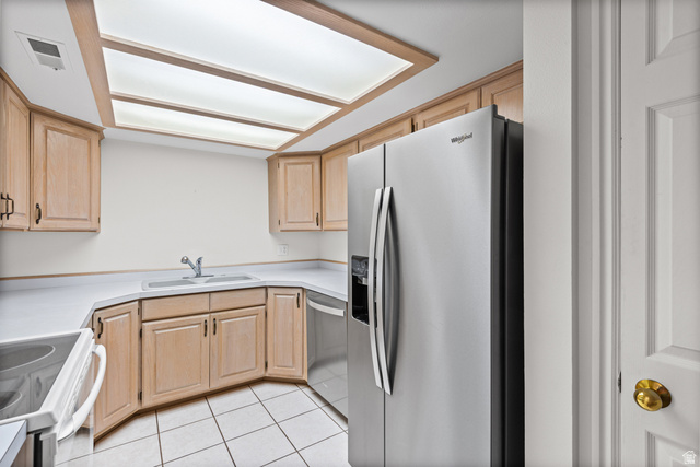 2244 North Canyon Road, Unit 212 Provo, UT 84604 - Photo 11 of 31 Neutral-toned cabinetry, white countertops, recessed ceiling light panels, stainless steel refrigerator, and tiled flooring