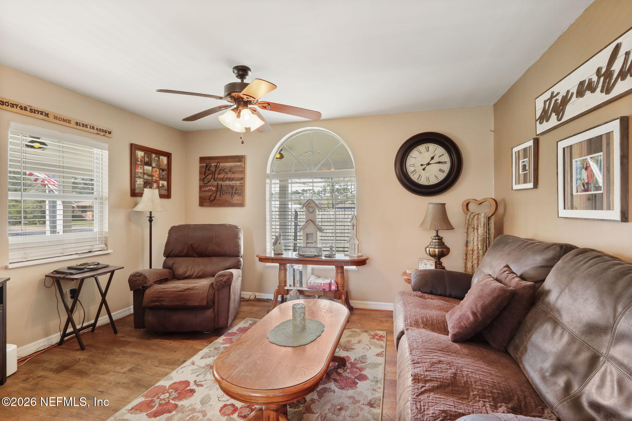 85930 North Harts Road Yulee, FL 32097 - Photo 13 of 50 a living room with furniture a clock on wall and a large window
