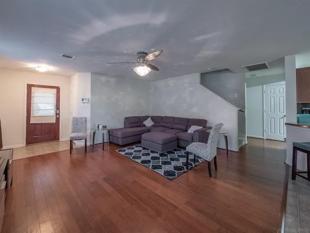 a living room with furniture and wooden floor
