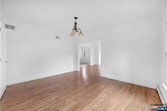 a view of a room with wooden floor and ceiling fan