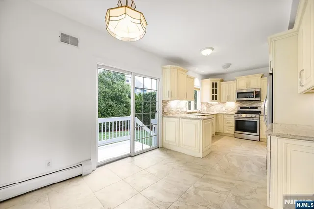 a kitchen with white cabinets and stainless steel appliances