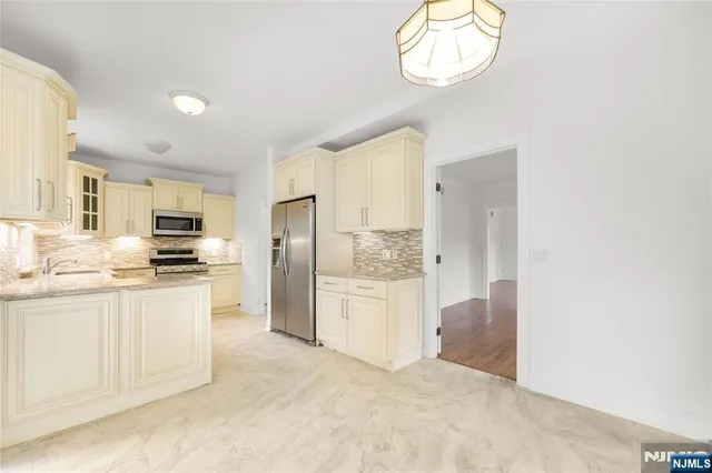 a kitchen with stainless steel appliances a refrigerator stove top oven and sink