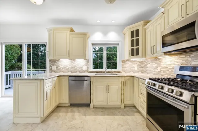 a kitchen with stainless steel appliances granite countertop a stove and a microwave