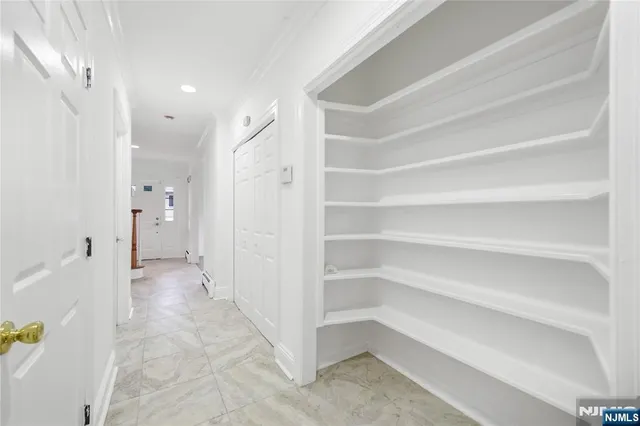 a view of a hallway with closet and a bathroom
