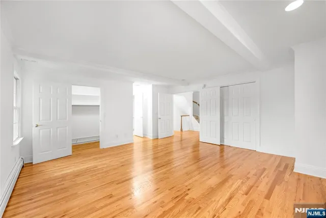a view of empty room with wooden floor