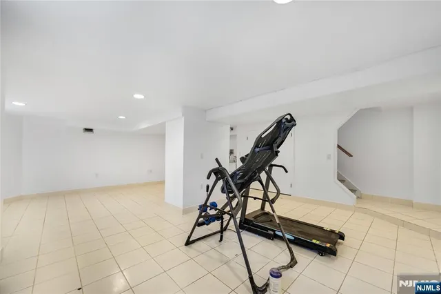 a room with gym equipment and wooden floor