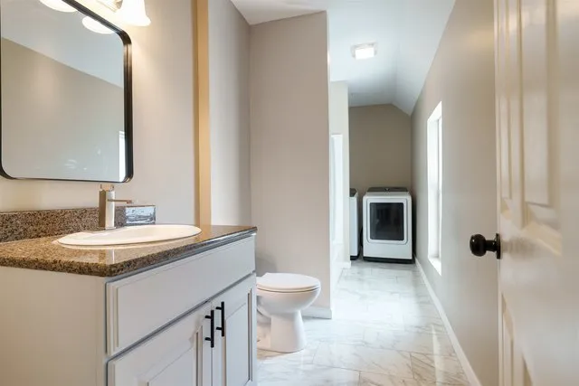 a bathroom with a granite countertop sink toilet a mirror and shower