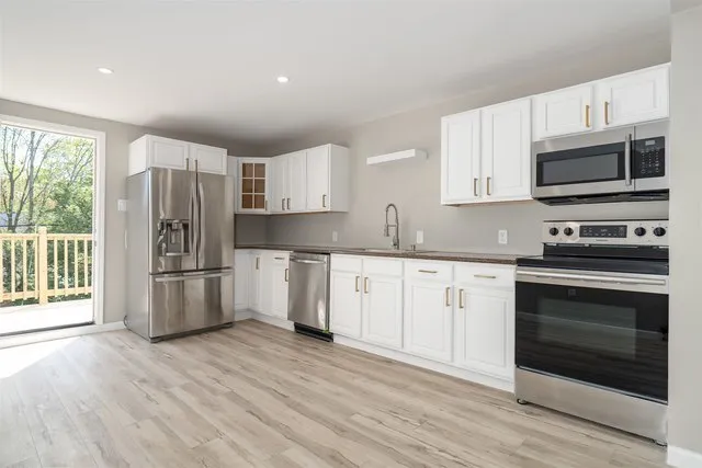 a kitchen with granite countertop a refrigerator stove and microwave