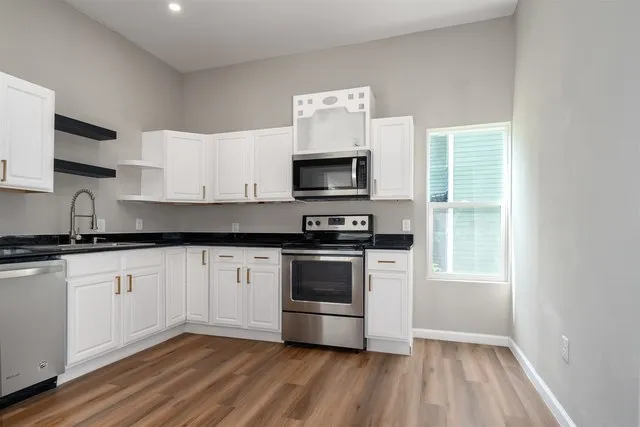 a kitchen with granite countertop a stove and a wooden floor