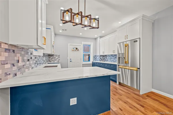 a kitchen with stainless steel appliances granite countertop a sink refrigerator and cabinets