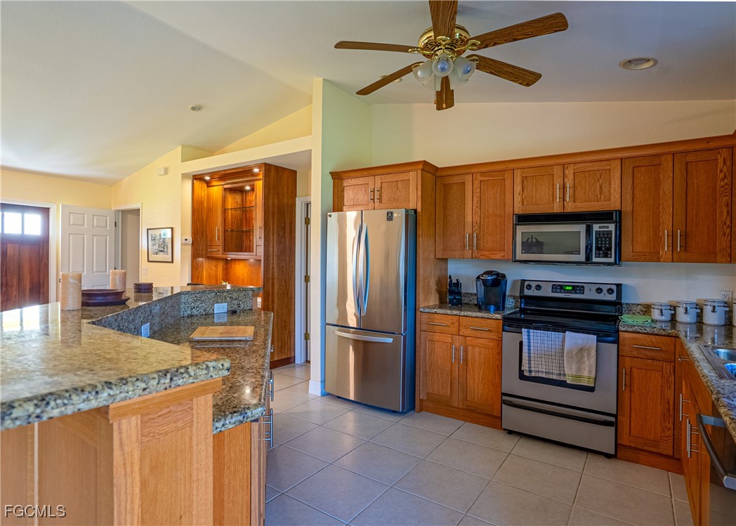 2516 13th Street Southwest Lehigh Acres, FL 33976 - Photo 12 of 16 a kitchen with stainless steel appliances granite countertop a refrigerator a stove and a sink