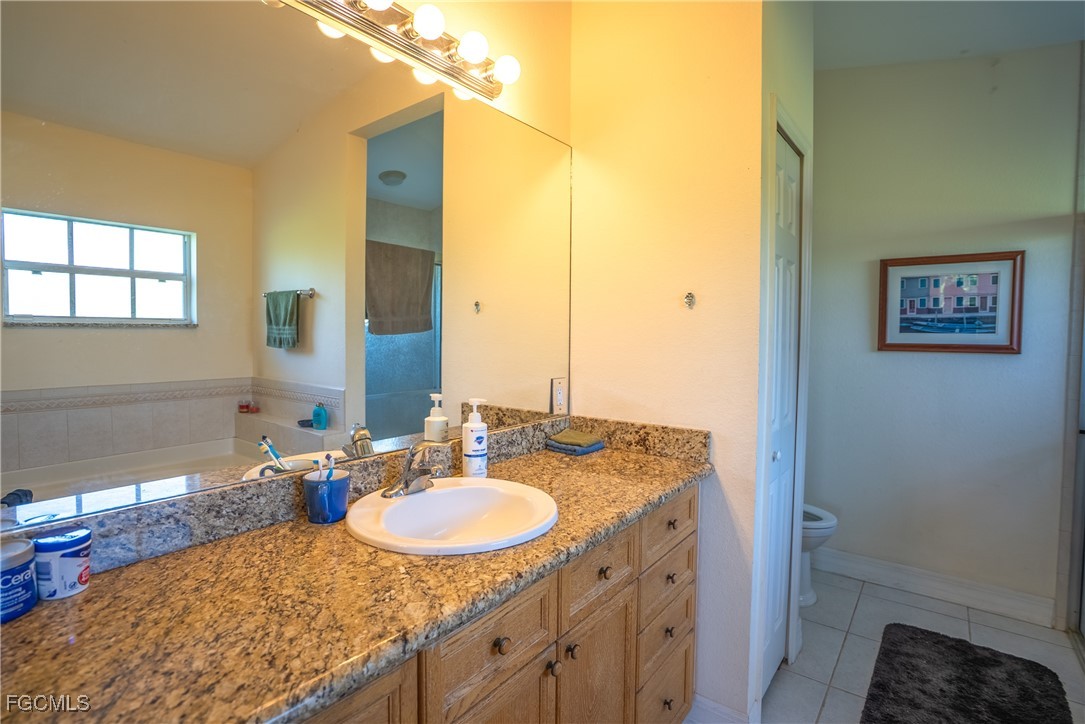 2516 13th Street Southwest Lehigh Acres, FL 33976 - Photo 6 of 16 a bathroom with a granite countertop sink and a mirror