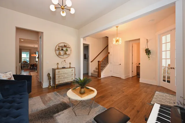 a large kitchen with stainless steel appliances kitchen island a stove a refrigerator a sink dishwasher and a dining table with wooden floor