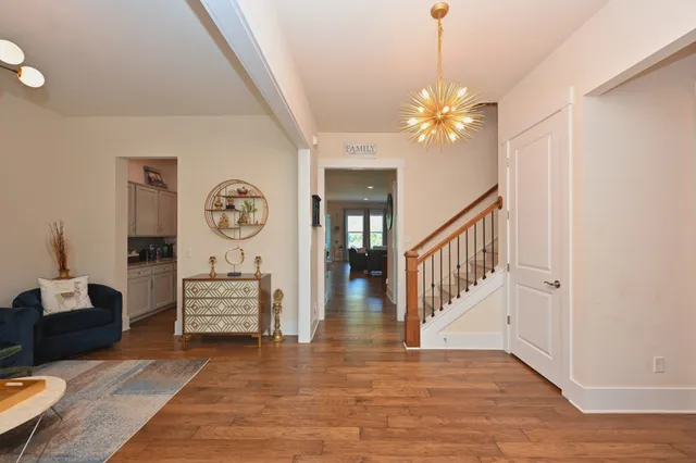 a kitchen with stainless steel appliances granite countertop a refrigerator a stove a sink dishwasher a dining table and chairs with wooden floor