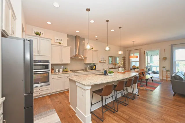 a living room with furniture a chandelier and a rug