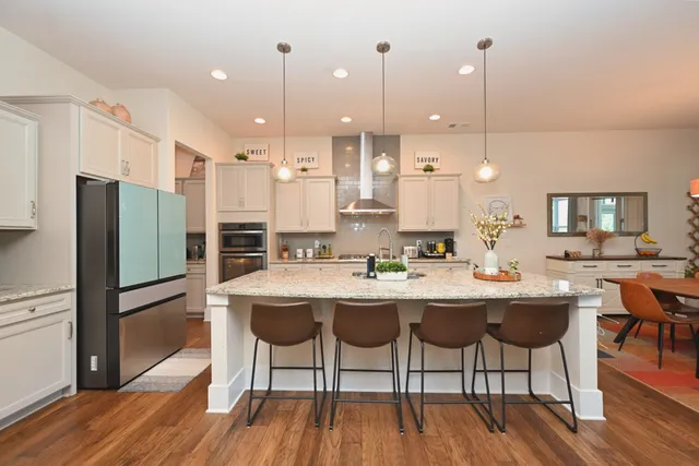 a bedroom with a bed chandelier and a window
