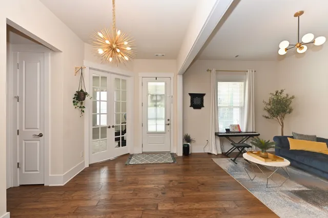 a living room with furniture a table and wooden floor