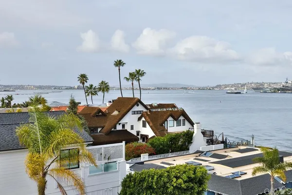an aerial view of a house with lake view and boat in the background