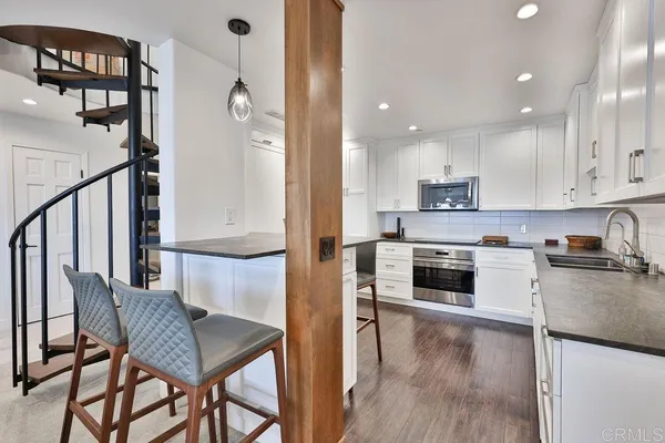 a kitchen with granite countertop a stove a sink and a refrigerator