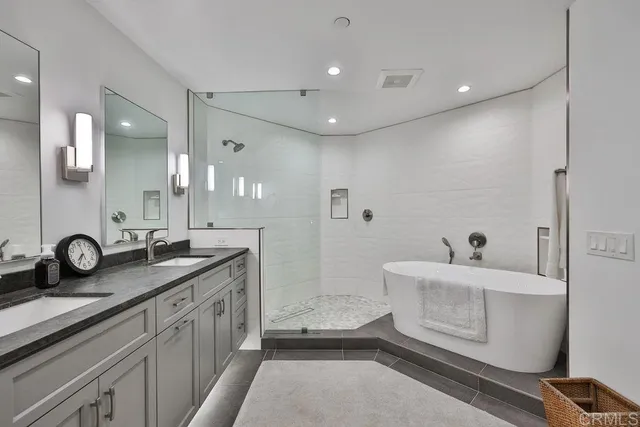 a bathroom with a double vanity sink a toilet a mirror and shower