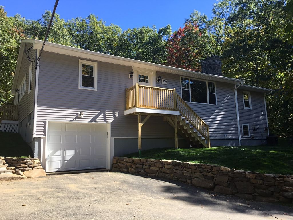 154 New Boston Road Sturbridge, MA 01566 - Photo 1 of 29 a front view of a house with a yard and garage