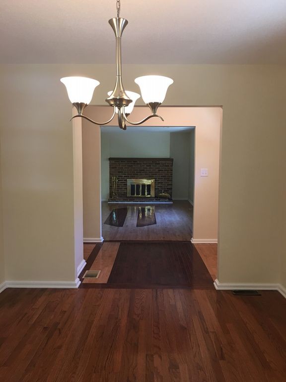 154 New Boston Road Sturbridge, MA 01566 - Photo 14 of 29 a view of a livingroom with a fireplace a chandelier wooden floor and chandelier