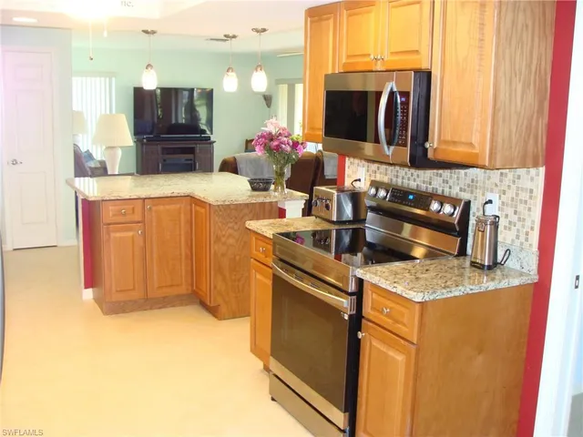 a kitchen with stainless steel appliances granite countertop a sink and a stove
