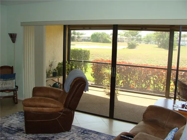 a living room with furniture and a floor to ceiling window
