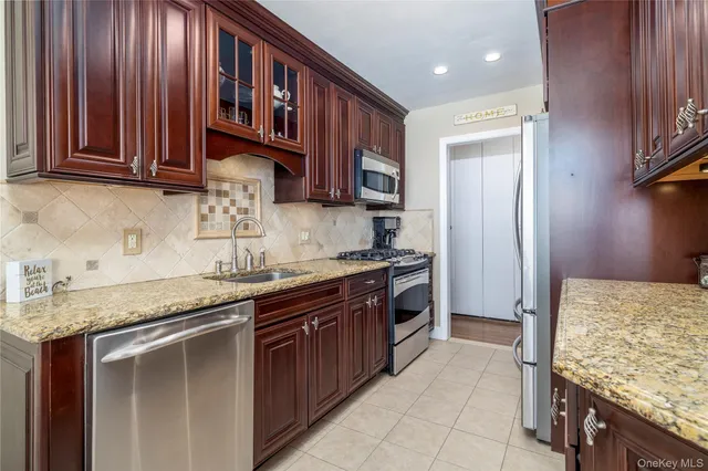 a kitchen with stainless steel appliances granite countertop wooden cabinets a sink and dishwasher