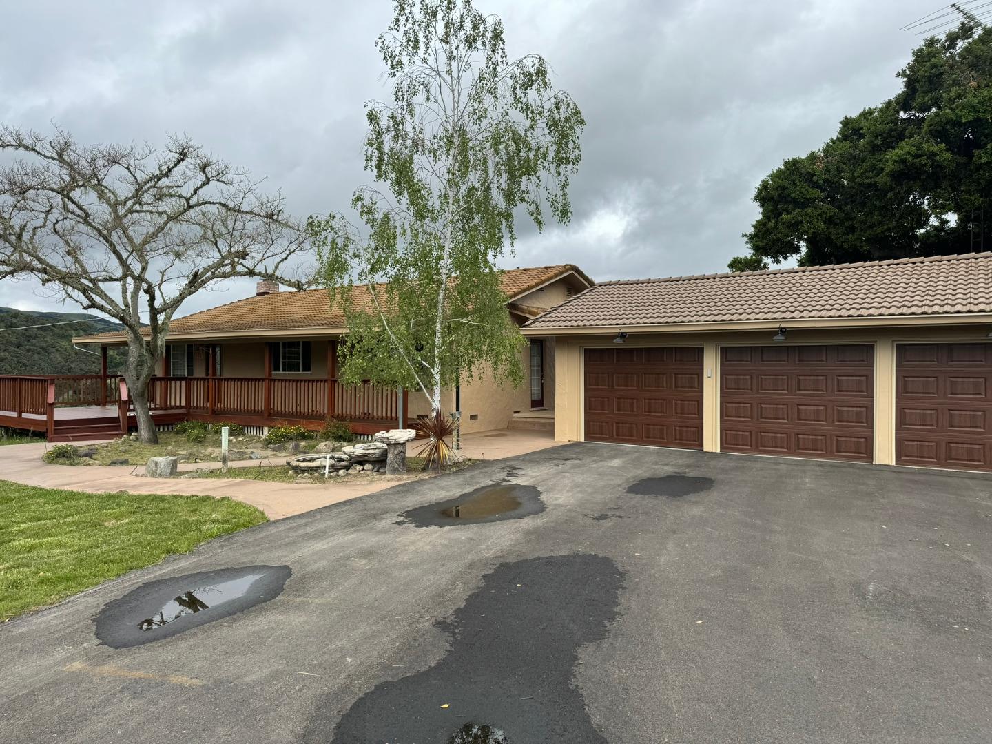 a front view of a building with garden and trees