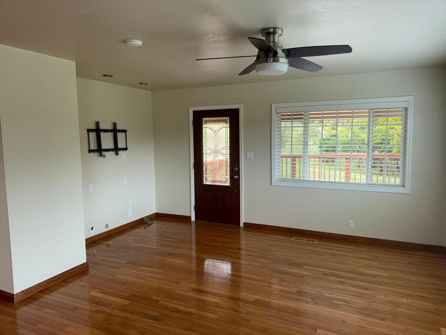 451 Corral De Tierra Road Salinas, CA 93908 - Photo 21 of 55 an empty room with wooden floor chandelier fan and windows