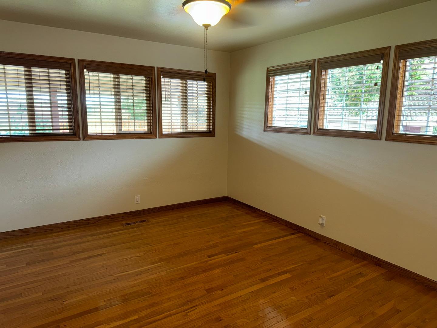 451 Corral De Tierra Road Salinas, CA 93908 - Photo 30 of 55 an empty room with wooden floor and windows