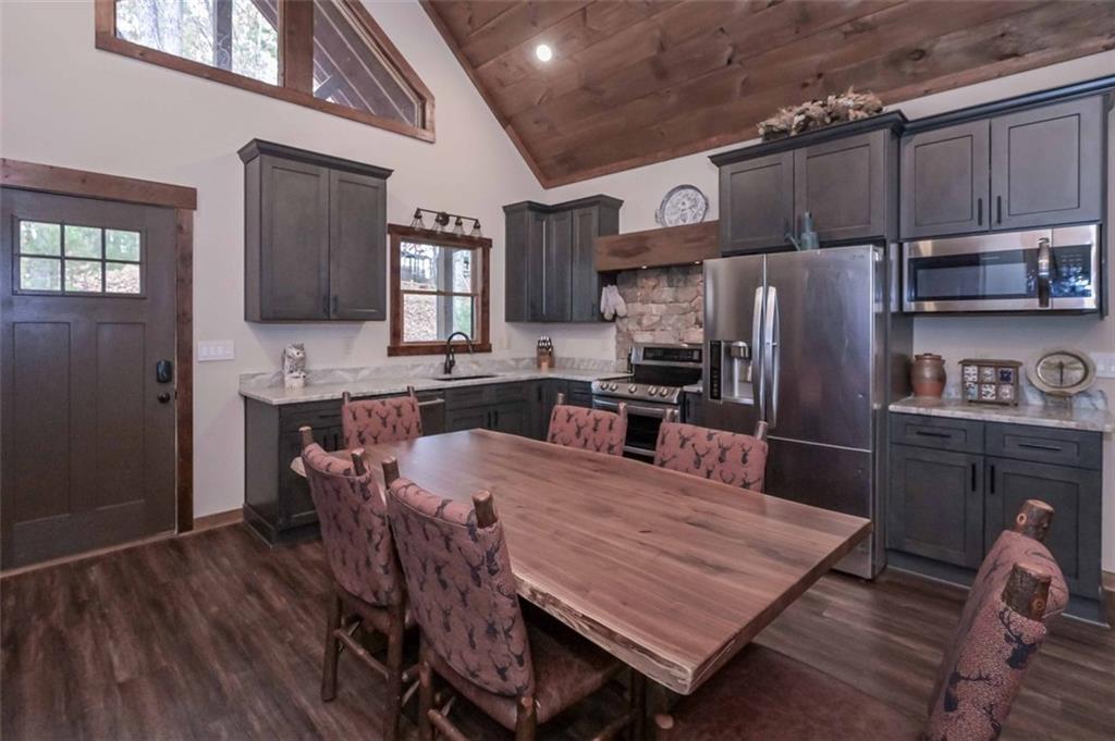 110 Ridge Crest Court Ellijay, GA 30540 - Photo 7 of 33 a kitchen with granite countertop a refrigerator a stove a sink a dining table and chairs