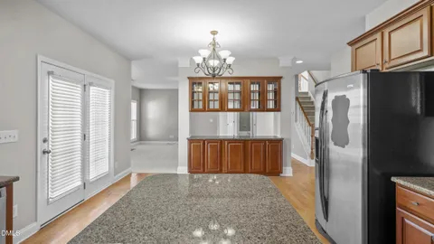 a large kitchen with granite countertop a large counter top stainless steel appliances a sink and cabinets