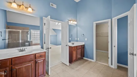 a bathroom with a double vanity sink mirror and shower