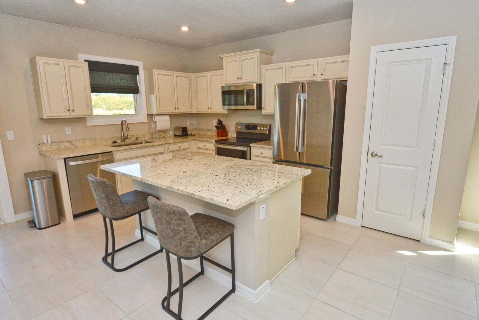 3524 Carriage Pointe Circle Fort Pierce, FL 34981 - Photo 14 of 55 a kitchen with stainless steel appliances granite countertop a table chairs sink refrigerator and microwave