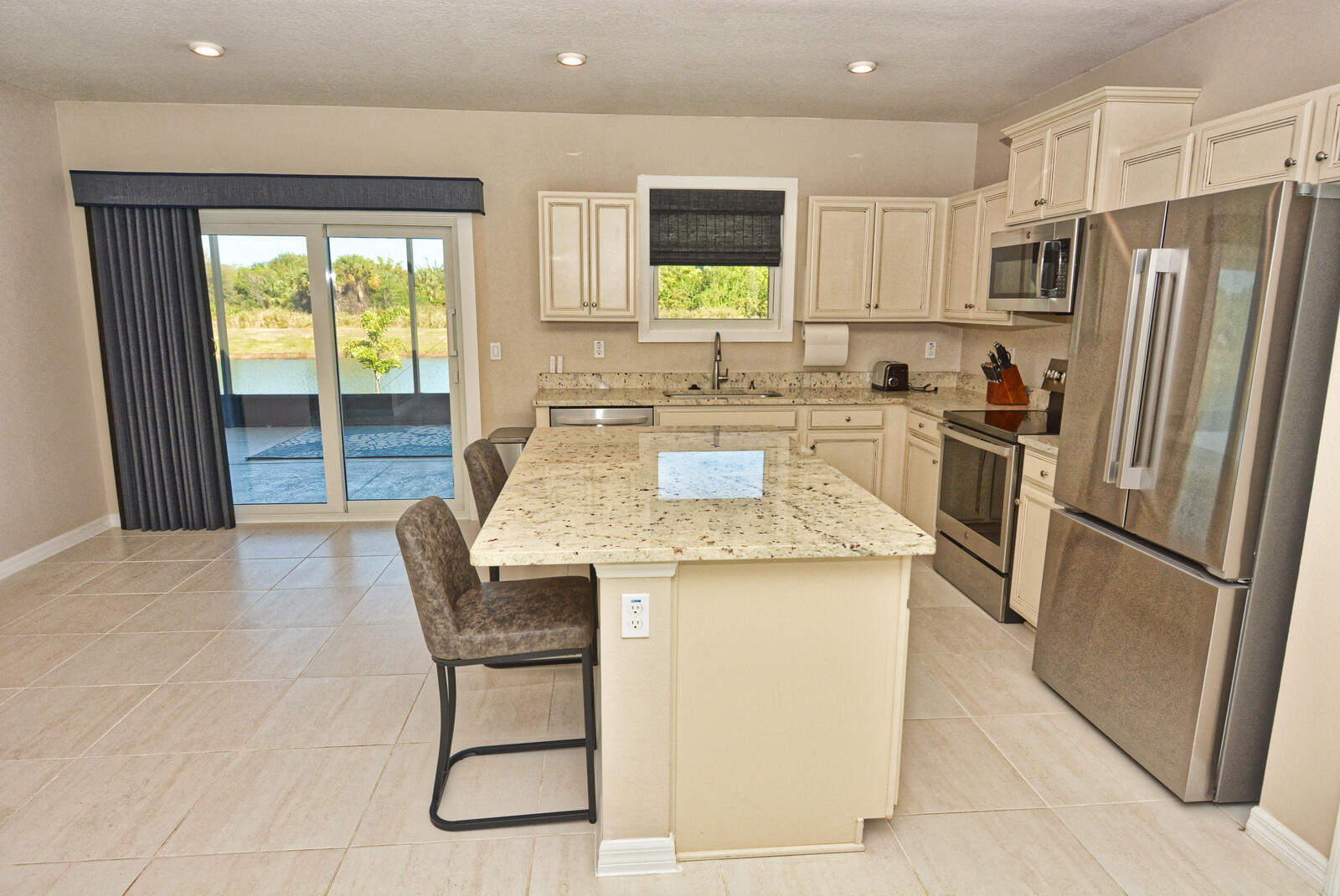 3524 Carriage Pointe Circle Fort Pierce, FL 34981 - Photo 10 of 55 a kitchen with stainless steel appliances granite countertop a stove a refrigerator a sink a dining table and chairs