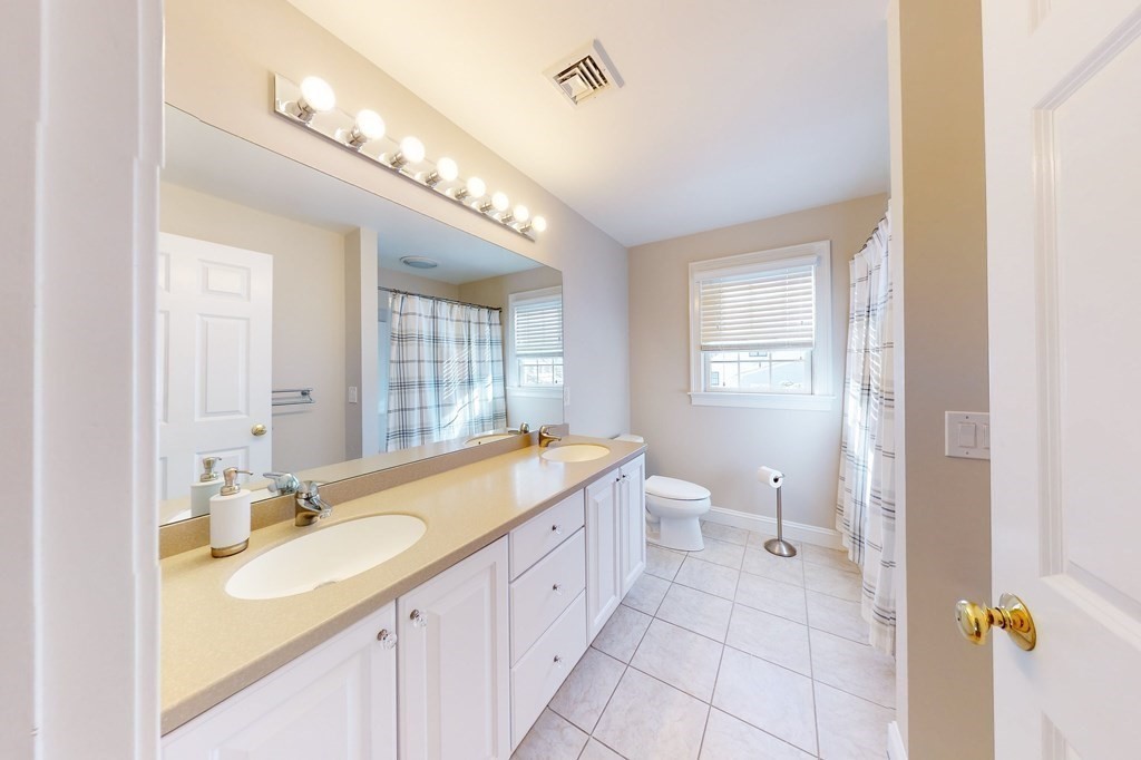 94 Arch Street Needham, MA 02492 - Photo 15 of 23 a spacious bathroom with a granite countertop double vanity sink a mirror and a bathtub