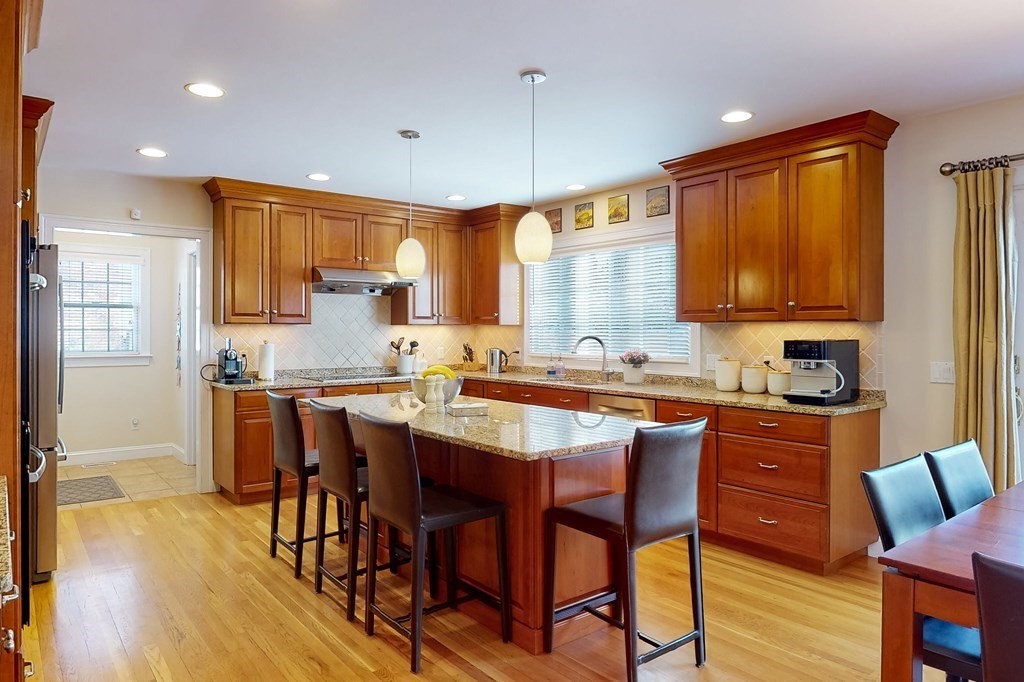 94 Arch Street Needham, MA 02492 - Photo 2 of 23 a kitchen with stainless steel appliances granite countertop wooden floor a stove a sink a refrigerator cabinets and dining table