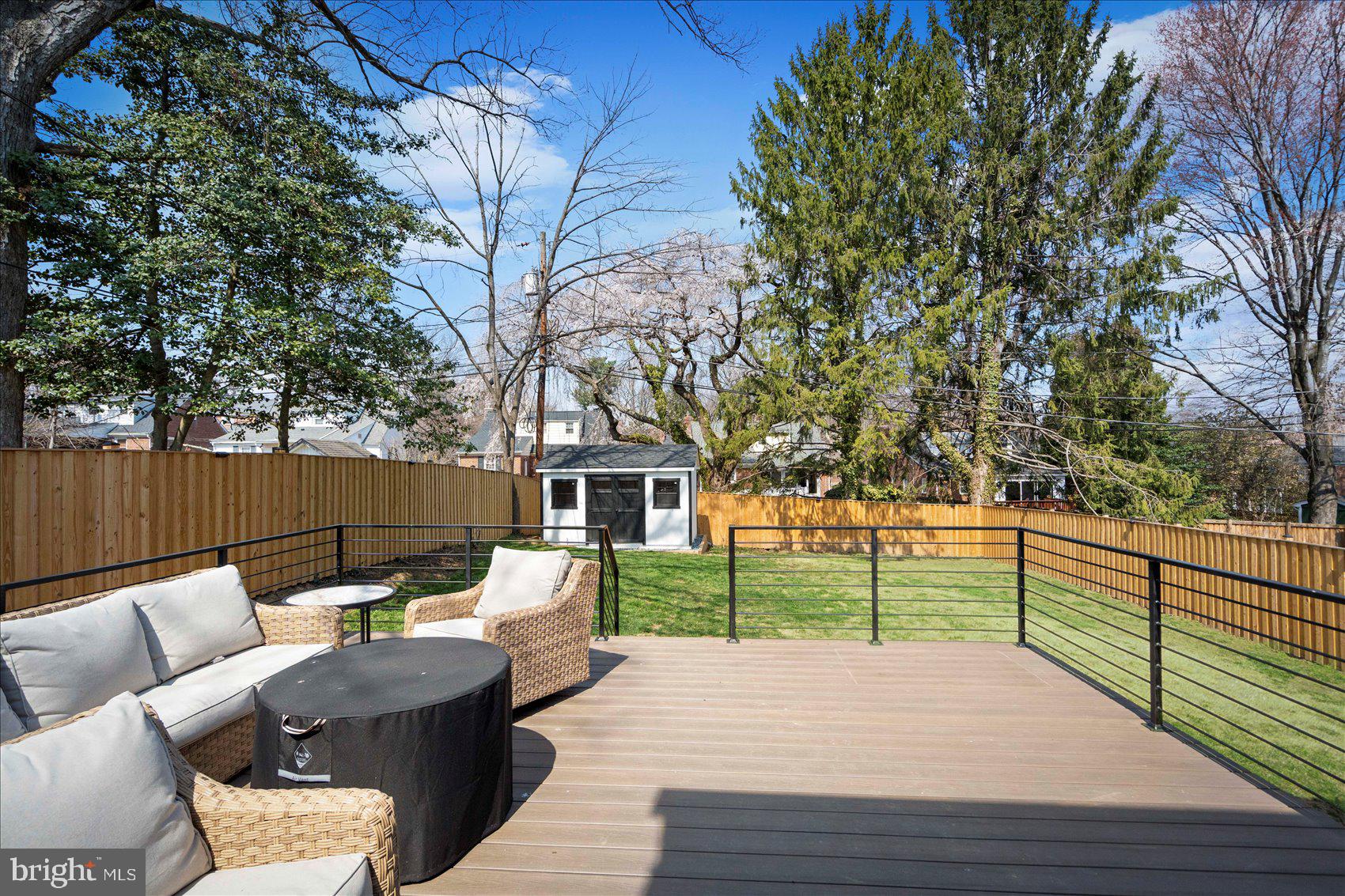 510 Overcrest Road Towson, MD 21286 - Photo 43 of 47 a view of a deck with couches table and chairs with wooden fence and large trees