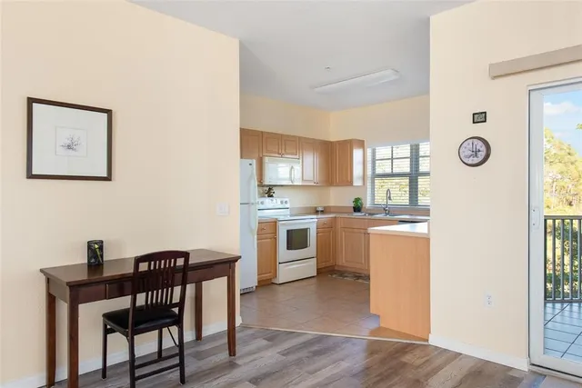 a kitchen with a table chairs and wooden floor