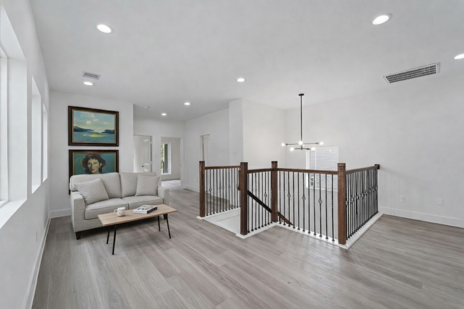 7709 Willow Street Houston, TX 77088 - Photo 10 of 15 This open upstairs space features light-colored wood-look laminate flooring and white walls with multiple recessed ceiling lights, the landing providing access to other rooms.