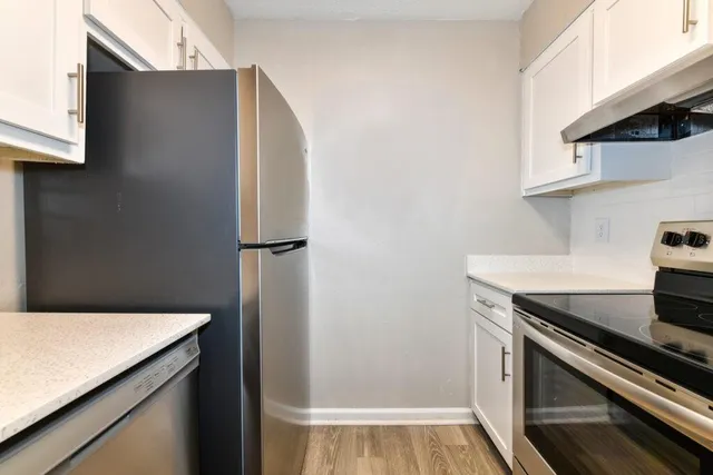 a kitchen with a refrigerator and a stove