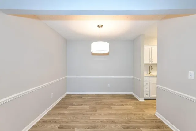 a view of a room with wooden floor and white walls