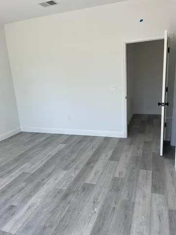 an empty room with wooden floor and closet