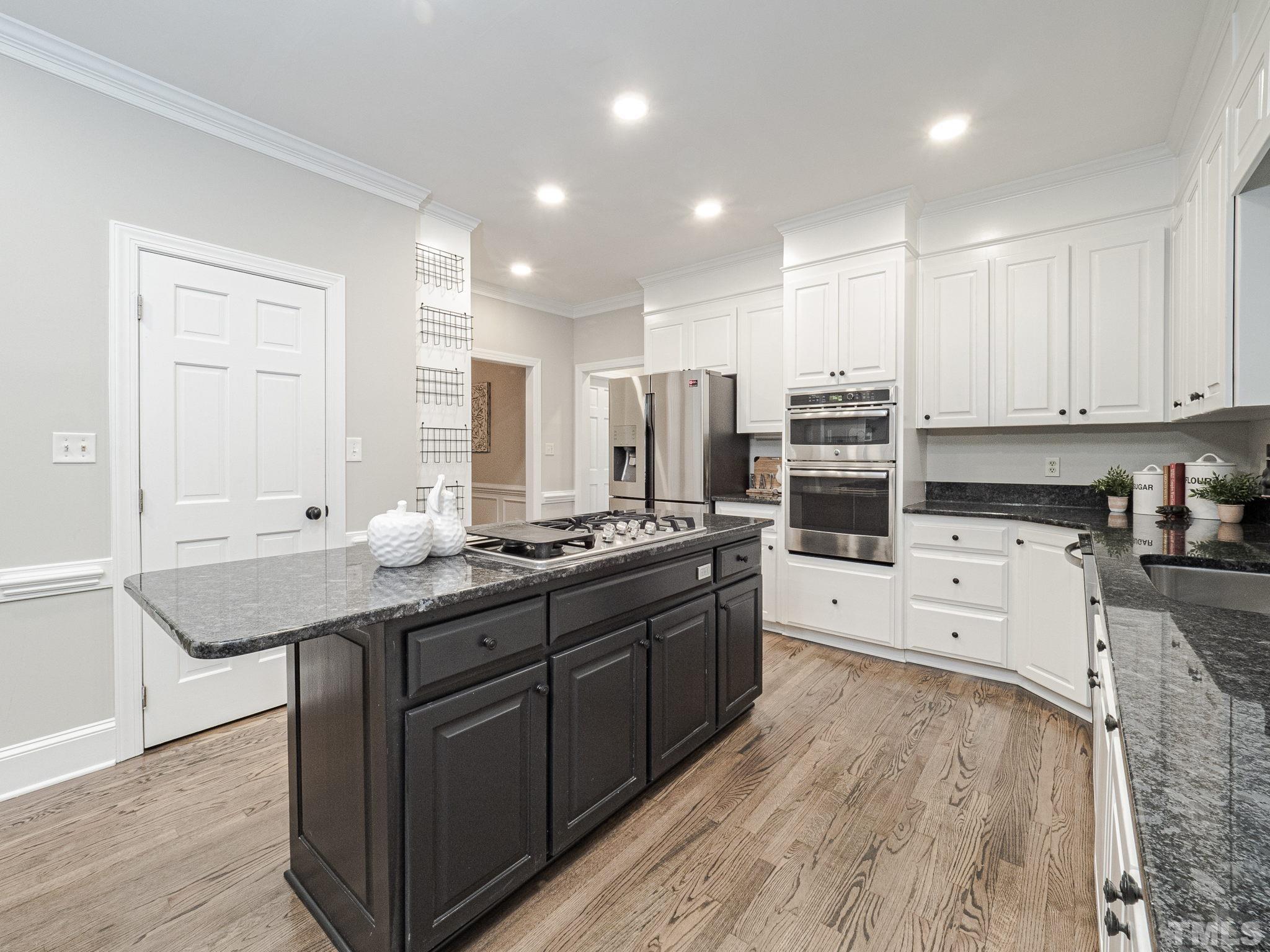 11936 Appaloosa Run East Raleigh, NC 27613 - Photo 15 of 30 a large kitchen with stainless steel appliances lots of counter space and wooden floor