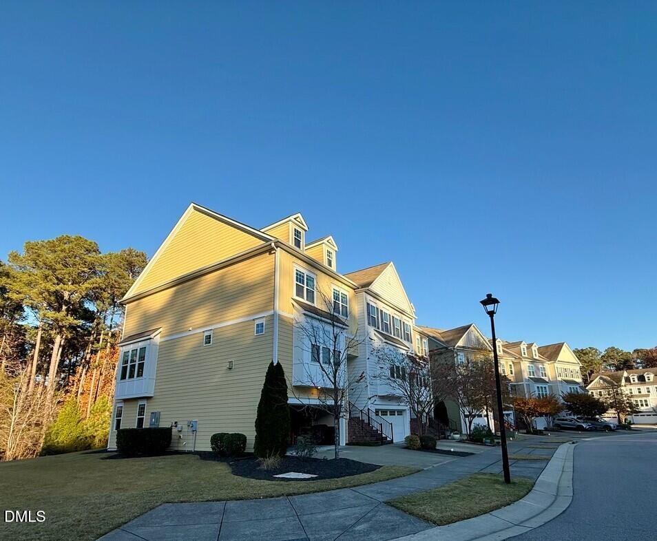 a view of a white house with a yard