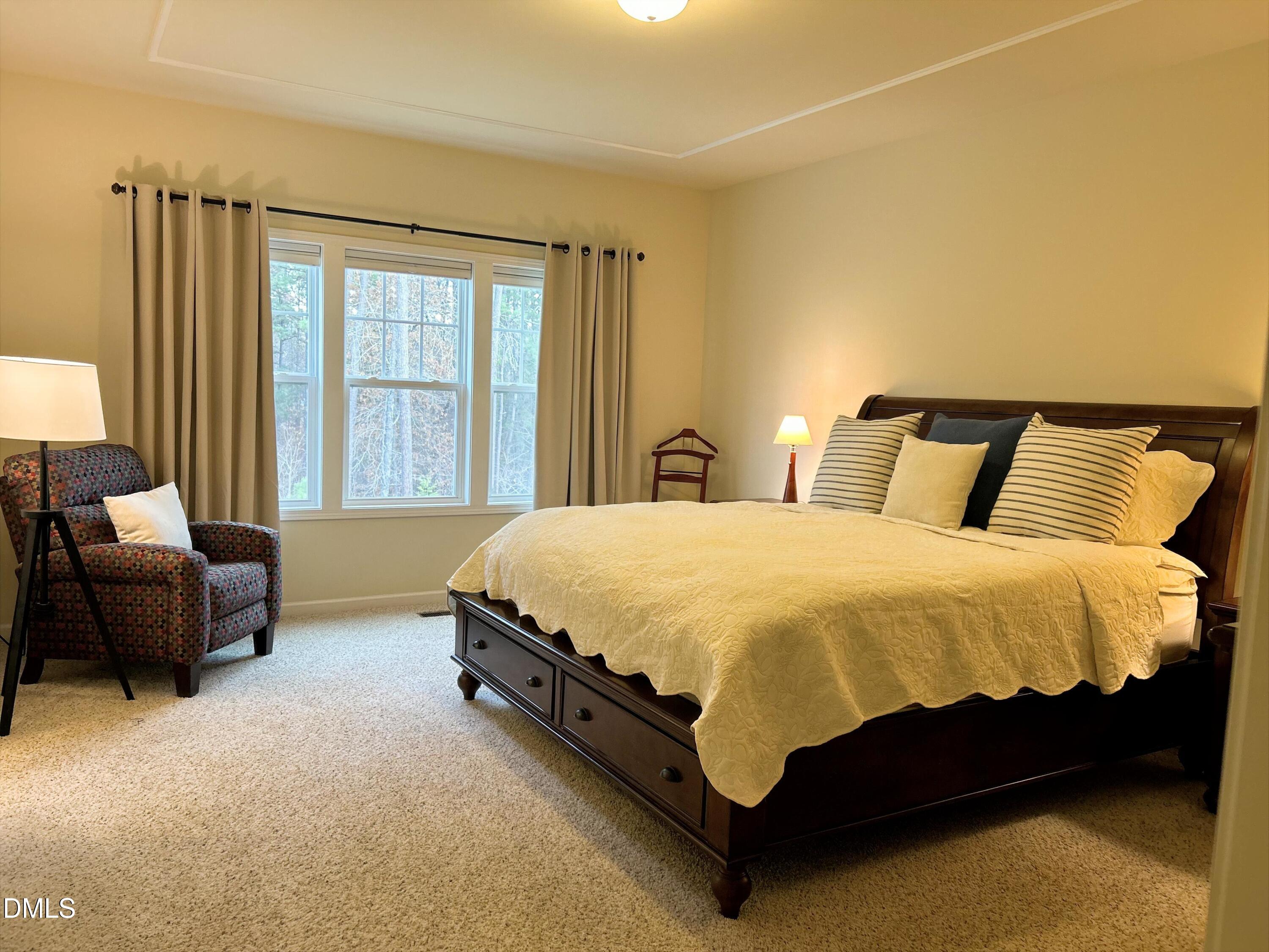 634 Edgewater Ridge Court Apex, NC 27523 - Photo 11 of 23 a spacious bedroom with a bed chair and a couch