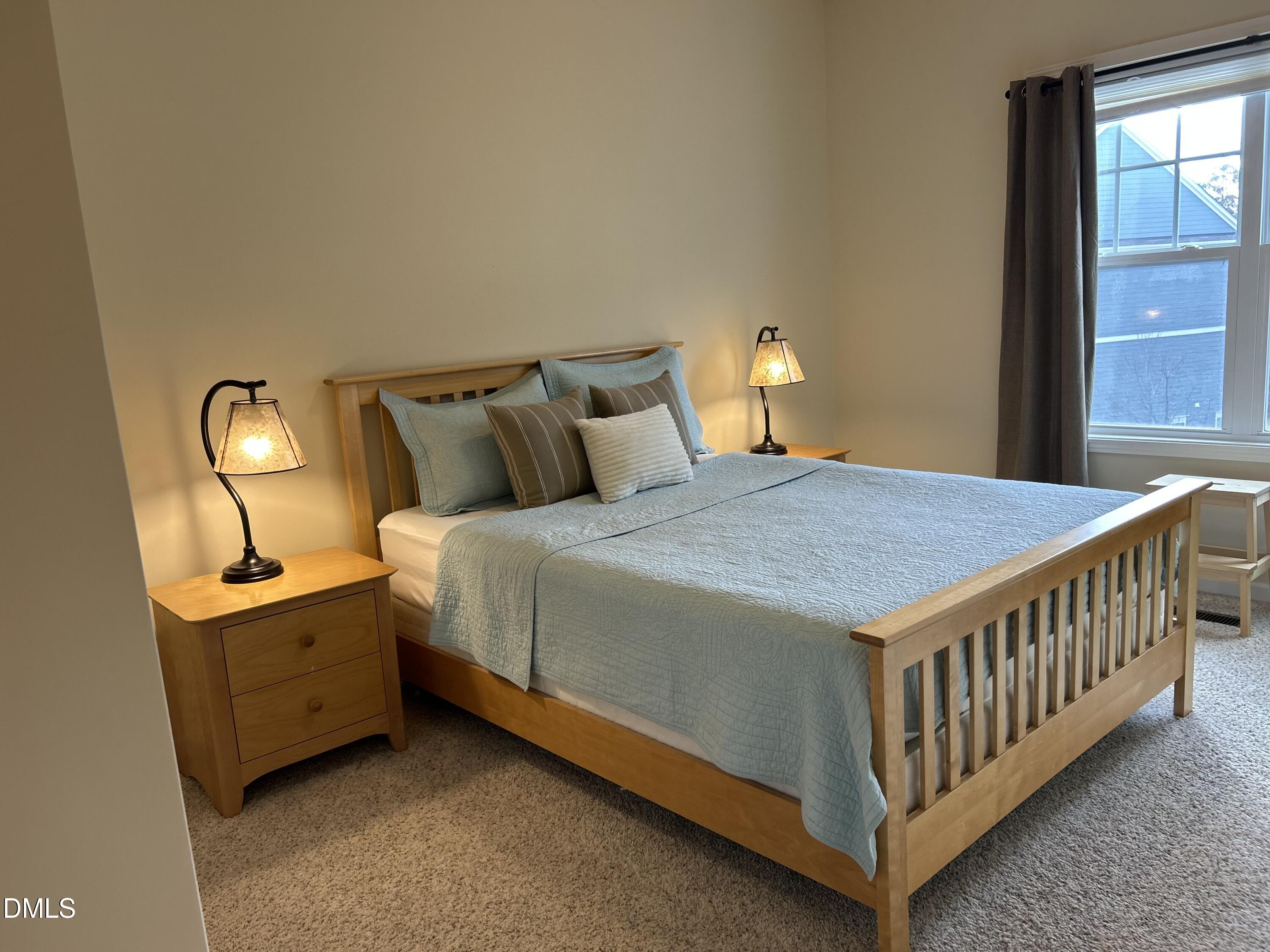 634 Edgewater Ridge Court Apex, NC 27523 - Photo 16 of 23 a bed sitting in a bedroom next to a window